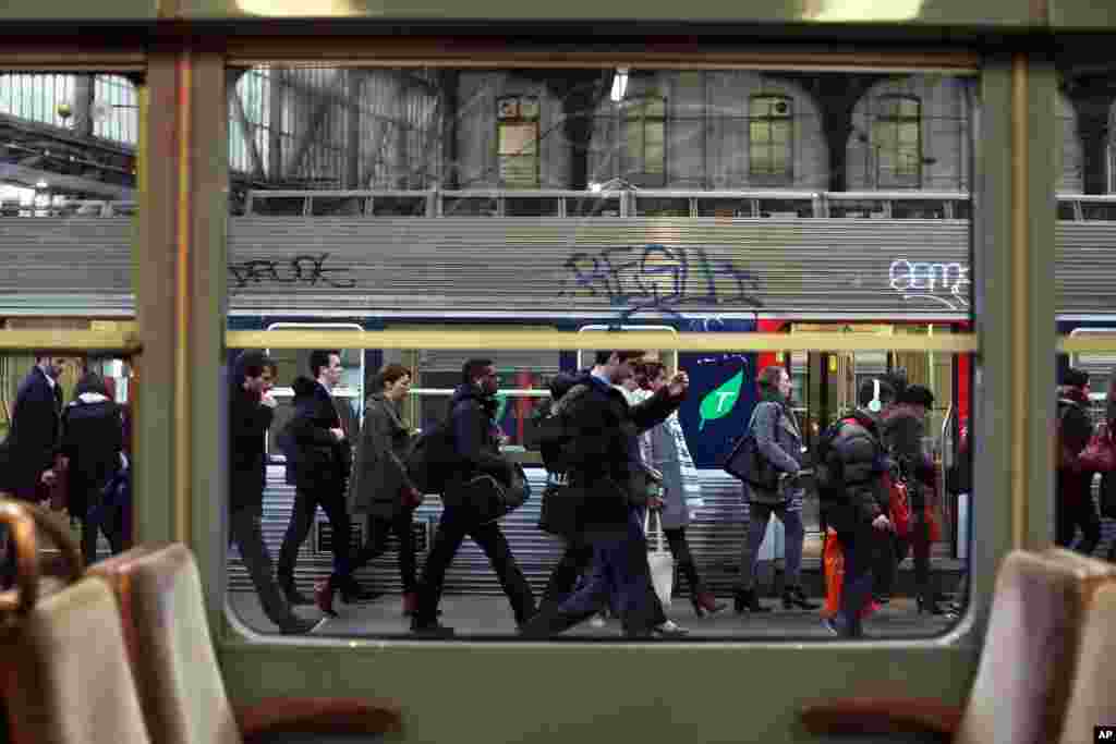 Commuters walk on a platform to catch a train at the Gare de l'Est train station in Paris. France's six rail unions have issued a joint call for a one-day strike that is set to disrupt local and national train traffic, but not international lines.
