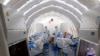 Sejumlah pekerja sedang bekerja di laboratorium pengujian COVID-19 di Beijing, China, 23 Juni 2020. (Foto: Chen Zhonghao/Xinhua via AP)