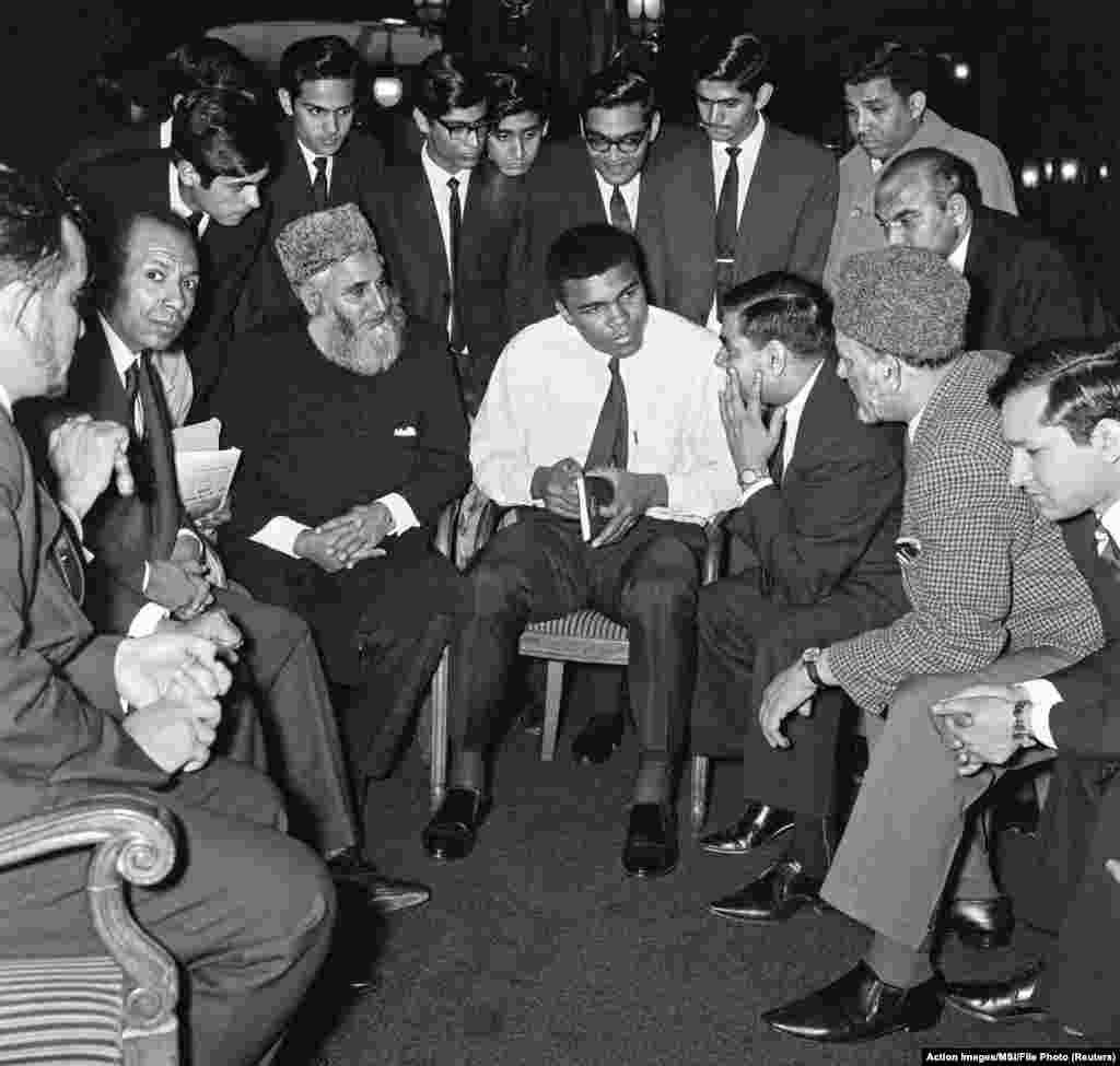 Muhammad Ali berbicara kepada komunitas Muslim sambil memegang buku "Menuju Pemahaman Islam" yang ditulis Sayyid Abul Ala Maududi di London, Inggris, Mei 1966. 