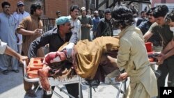 A man, who was injured in a bomb blast, is wheeled on a stretcher to a hospital, in Peshawar, Pakistan, June 8, 2012.