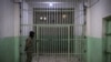 FILE - A member of the Syrian Democratic Forces (SDF) stands guard in a prison in the city of Hasakeh, Syria, Oct. 26, 2019.