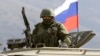 FILE - An armed man, believed to be a Russian serviceman, stands guard outside a Ukrainian military base in Perevalnoye, near the Crimean city of Simferopol, March 14, 2014. Authorities released RFE/RL journalist Nikolai Semena on bail, but with travel restrictions, according to a report quoting his lawyer, April 19, 2016.