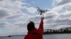 Drone operator Parker Gyokeres helps to retrieve a drone after photographing over Hart Island in New York, April 29, 2018.