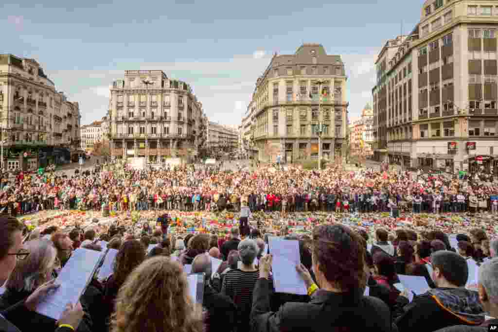 Dozens of professional singers and a few hundred people sing famous Belgian songs at a memorial site for the victims of the Brussels attacks at the Place de la Bourse in Brussels.