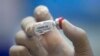 A medical worker in protective suit conducts tests for residents in Wuhan, the Chinese city hit hardest by the coronavirus disease, Hubei province, China, May 15, 2020. A small trial of a coronavirus vaccine in Wuhan showed "unimpressive" results.