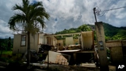 FILE - In this Sept. 8, 2018 file photo, a home that was abandoned after Hurricane Maria hit one year ago stands full of furniture in the San Lorenzo neighborhood of Morovis, Puerto Rico.