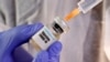 USA, Washington, FILE PHOTO: A woman holds a small bottle labeled with a "Vaccine COVID-19" sticker