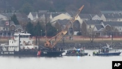 Član ronilačkog tima i brod obalske straže s dizalicom rade u blizini olupine helikoptera Black Hawk u rijeci Potomac sa Nacionalnog aerodroma Ronald Reagan Washington, 31. januara 2025., u Arlingtonu, Va.