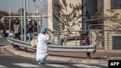 Un agent de santé sud-africain porte un équipement de protection individuelle (EPI) complet alors qu'elle se promène à l'intérieur de l'hôpital Chris Hani Baragwanath à Soweto, le 18 juillet 2020.