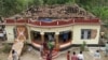 People gather around a damaged section of a temple after a fire broke out at a temple in Kollam in the southern state of Kerala, India, April 10, 2016. 