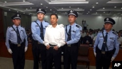 Mantan anggota tertinggi Partai Komunis China, Bo Xilai, diborgol dan dikawal oleh polisi saat berdiri di pengadilan di Jinan, provinsi Shandong, China, 22 September 2013 (Foto: dok). 