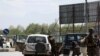 FILE - Afghan security forces inspect the site of a bomb explosion near a damaged vehicle in Kabul, Afghanistan,, April 27, 2020. 