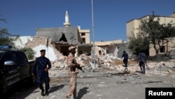 Des membres de la sécurité inspectent le site d'une frappe aérienne de nuit, qui a attaqué un quartier résidentiel de Tripoli, en Libye, le 14 octobre 2019.