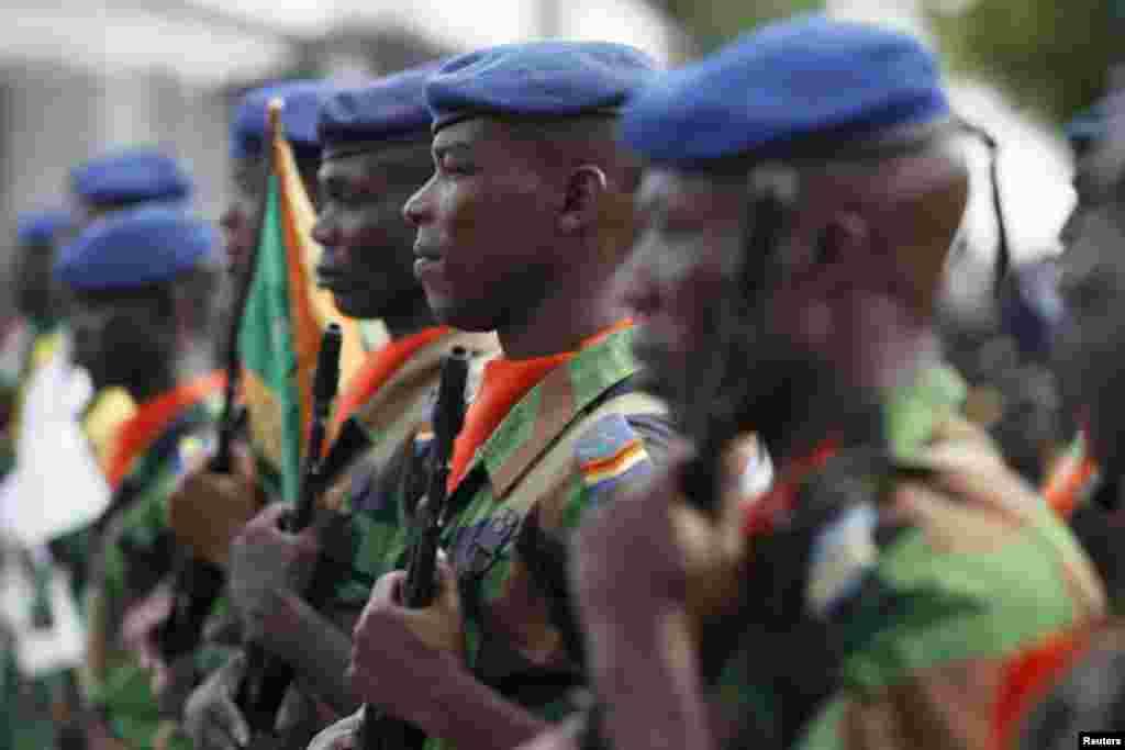 Ivory Coast soldiers stand at guard during a ceremony in Abidjan to honor soldiers killed in last month's al-Qaida attack on the beach resort town of Grand Bassam.