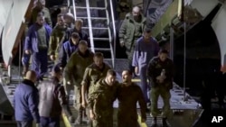 Un groupe de prisonniers de guerre russes quitte un avion militaire russe après avoir été libérés le 22 septembre 2022.
