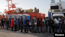 Migranti stoej u redu dok im pomažu aktivisti španskog Crvenog krsta nakon što su ih spasilački brodovi dovezli u luku Algeciras, južna Španija, 22. jula 2018.