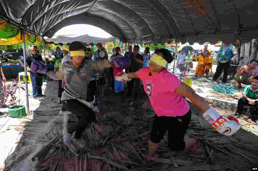 Dua perempuan Thai ini ambil bagian dalam pertarungan tinju dengan mata tertutup sebagai bagian dari perayaan Festival Songkran yang menandai tahun baru bagi warga Thailand di provinsi Narathiwat, Thailand Selatan. Tahun baru Thai jatuh pada tanggal 13 April. 