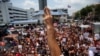 FILE - Thanathorn Juangroongruangkit, leader of the Future Forward Party flashes a three finger salute to his supporters as he leaves a police station after hearing a sedition complaint filed by the army in Bangkok, Thailand, Apr. 6, 2019. 