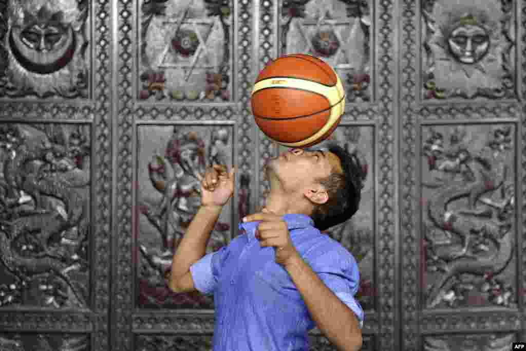 Thaneswar Guragai berusaha memecahkan Rekor Dunia Guinness dengan memastikan bola basket berputar pada hidungnya selama tujuh detik, di Kathmandu, Nepal.