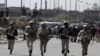 Egyptian military police soldiers run towards a checkpoint attacked by gunmen in Shubra al-Kheima, a suburb north of Cairo, Egypt, Saturday, March 15, 2014.