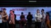 Para pengguna kereta api menunggu di depan iklan penyedia jasa layanan internet di Stasiun Sudirman, Jakarta, 9 Agustus 2016. (Foto: Reuters)
