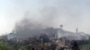 A picture taken with a smart phone shows smoke rising in the village of al-Hosn in the Homs region, about 200 kilometers northwest of Damascus, Syria, March 20, 2014.
