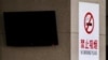 一名中国男子在北京一处明令禁止吸烟的公车站吸烟