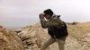In this photo, which has been authenticated based on its contents and other AP reporting, a Syrian rebel looks through his binocular at one of the frontline of Yabroud town, the last rebel stronghold in Syria's mountainous Qalamoun region, Mar. 13, 2014. 