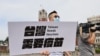 A lawmaker from Taiwan's main opposition Kuomintang (KMT) Party holds signs calling for the government to accept all vaccines and provide free vaccines for all citizens, in front of the Presidental building in Taipei, Taiwan, June 4, 2021. 