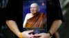 FILE - A man holds a portrait of Thailand's Supreme Patriarch, Somdet Phra Nyanasamvara Suvaddhana Mahathera, at Chulalongkorn Hospital in Bangkok, October 25, 2013. 