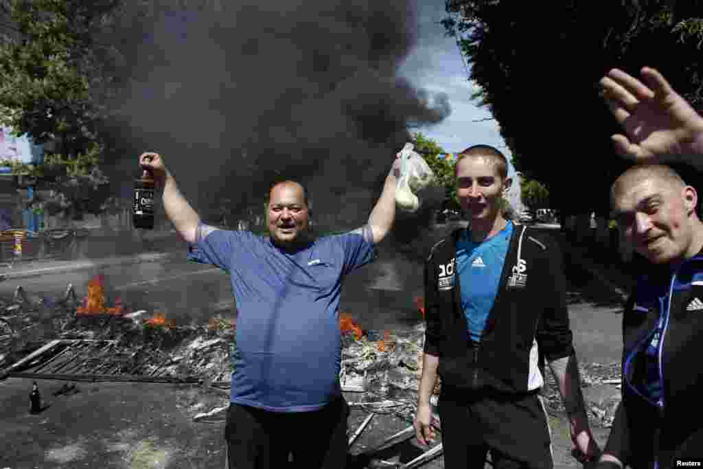 Warga di depan barikade yang dibakar dekat balai kota Mariupol, Ukraian timur (10/5).