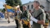 FILE - Volunteers of battalion 'Donbas' hold battalion flags during a blessing ceremony in St. Michael Cathedral in Kyiv, Ukraine.