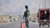 FILE - An Afghan policeman stands guard at a checkpoint on the outskirts of Mazar-i-Sharif, in Balkh province, Sept. 5, 2015.