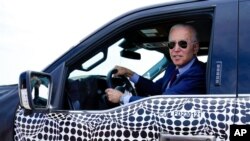 President Joe Biden stops to talk to the media as he drives a Ford F-150 Lightning truck at Ford Dearborn Development Center, in Dearborn, Mich., May 18, 2021.
