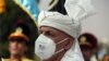 FILE - Afghan President Ashraf Ghani, wearing a mask to help curb the spread of the coronavirus, sings the national anthem at the Independence Minaret monument during the Independence Day celebrations in Kabul, Afghanistan, Aug. 18, 2020.