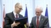 Ukrainian Prime Minister Arseniy Yatsenyuk (left) and European Council President Herman Van Rompuy exchange documents at the signing ceremony in Brussels on March 21.