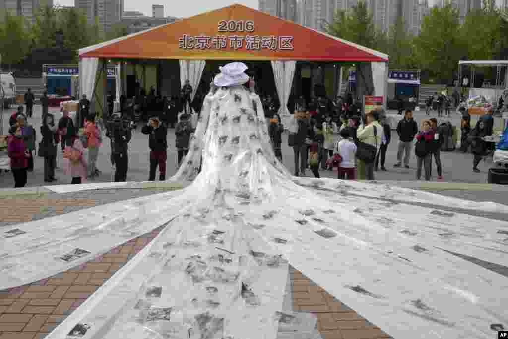 Chinese artist Kong Ning wears a gown to promote her poetry works at a book fair in Beijing.