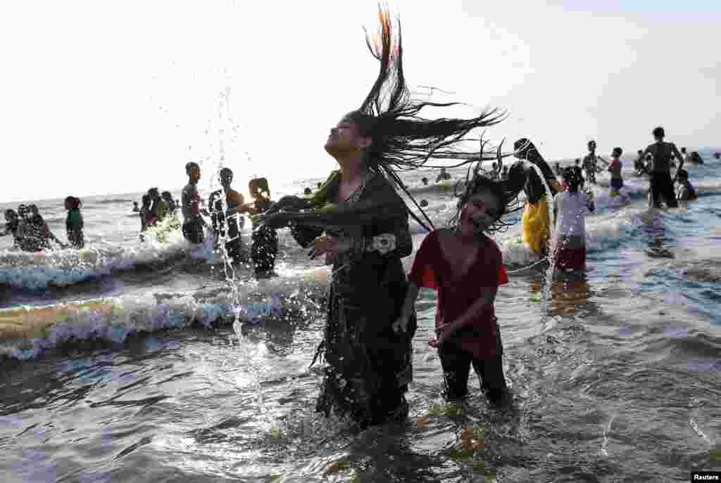 People play on a beach along the Arabian Sea on a hot summer day in Mumbai, India.