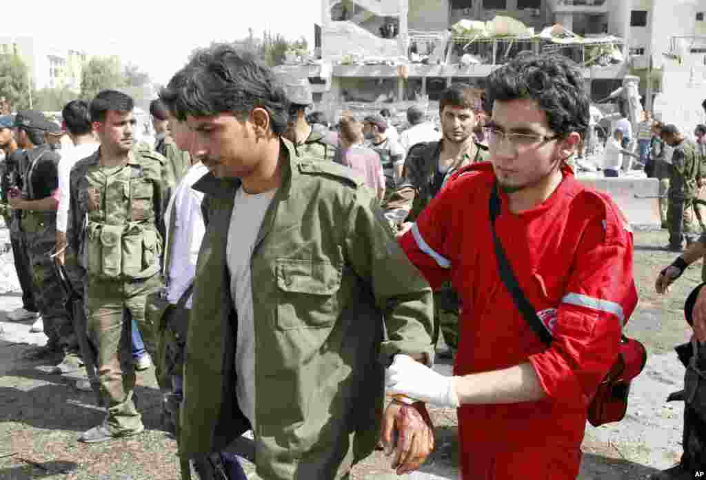 A medic helps a wounded soldier at the site of an explosion in Damascus.
