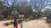 Children walks past the gate of school closed in Harare on September 22, 2020 (C. Mavhunga/VOA)