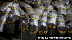 Para aparat kepolisian tampak melindungi diri mereka dengan tameng ketika melakukan pengamanan dalam aksi unjuk rasa penentangan terhadap Undang-undang Omnibus di Jakarta, pada 13 Oktober 2020. (Foto: Reuters/Willy Kurniawan)
