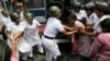 Indian policewomen detain an activist of Socialist Unity Center of India during a daylong nationwide strike in Kolkata, India, Sept. 2, 2015.