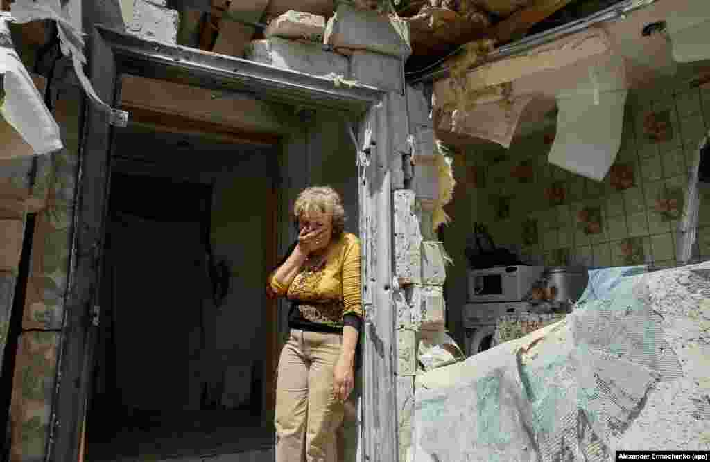 A local woman reacts as she looks at her destroyed home after shelling in the pro-Russian rebel-controlled Staromykhaylivka village near Donetsk, Ukraine, 24 May 2016.