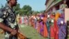 Indian security personnel guard as women voters stand in a queue to cast their votes at a polling station during the first of the five phase voting for state legislative assembly at Mahmoodpur village, in Samastipur district of India’s eastern state Bihar, Oct. 12, 2015.