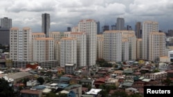 FILE - Rows of condominium buildings are seen behind a middle-class residential district in Mandaluyong, Metro Manila. The economy grew 6.4 percent in the first three months of the year, second only to China, July 4, 2012.