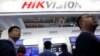 Para pengunjung melintas di depan stan produsen peralatan pengintaian China, Hikvision, di sebuah pameran di Beijing, China, 23 Oktober 2018. (Foto: AP/Ng Han Guan). 