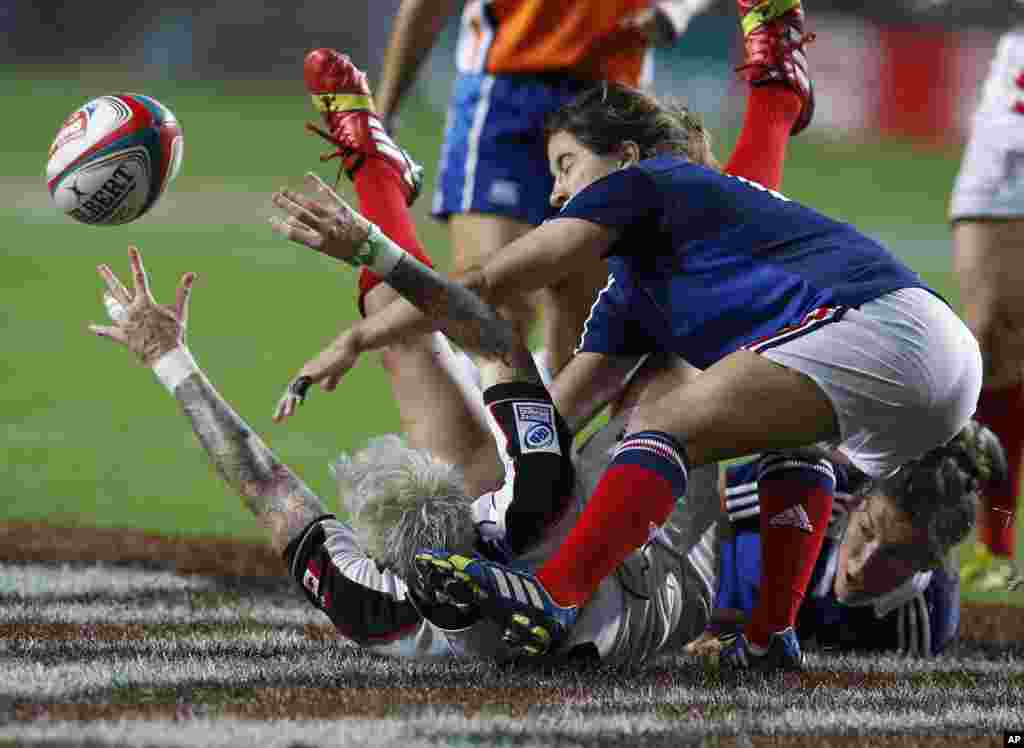Pemain Kanada Jennifer Kish (kiri) di tanah, dihadang oleh pemain Perancis Jade Le Pesq (kanan) dalam pertandingan final Piala Invitational Putri di Turnamen Rugby Hong Kong Sevens. &nbsp;