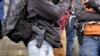 FILE - Men stand with pistols strapped at their sides at a gun rights rally on the steps of the Washington state capitol, Jan. 15, 2016, in Olympia, Wash.