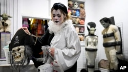 Olive Luther prepares to stock costume displays at The Theatrical Shop, Oct. 29, 2024, in West Des Moines, Iowa.