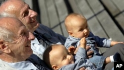In this Saturday, June 18, 2005 file photo, identical twins Alf, left, and Sven Fehnhanhn, left background, 79, from Kassel, Germany, pose along with seven-month-old Luis Carl, right, und Albert Frank Millgramm, right background, during a twins' meeting i